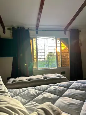 a bedroom with two beds in front of a window at ATGAL Ferme D'hote in Azrou