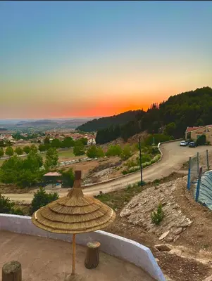 an umbrella sitting on top of a building with a sunset at ATGAL Ferme D'hote in Azrou