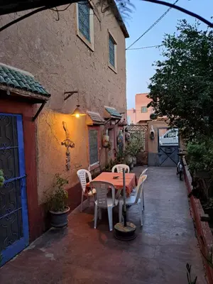 a patio with a table and chairs and a building at DAR JOUD in Tabourahte