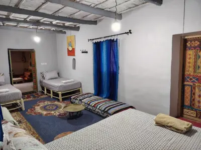 a room with two beds and a couch and a table at DAR JOUD in Tabourahte