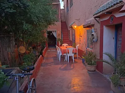 a patio with a table and chairs in an alley at DAR JOUD in Tabourahte