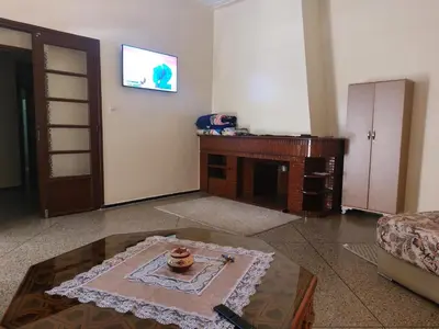 a living room with a table and a tv at Studio Hamria Meknes in Meknès