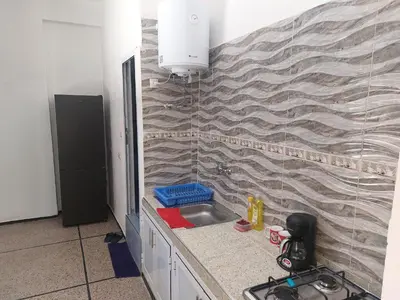a kitchen with a sink and a brick wall at Studio Hamria Meknes in Meknès