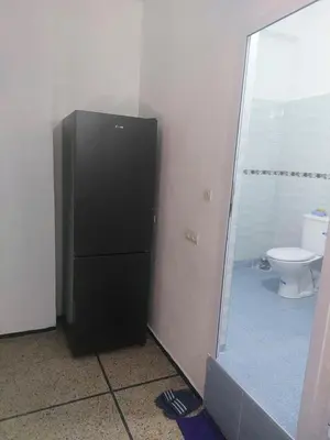 a black refrigerator in a bathroom with a toilet at Studio Hamria Meknes in Meknès