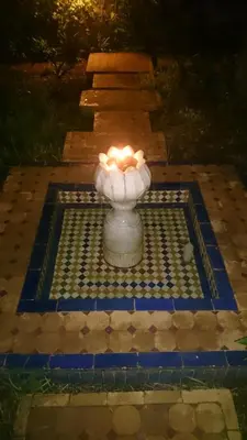 a candle in a vase on a tile floor at Riad Au 20 Jasmins in Fès