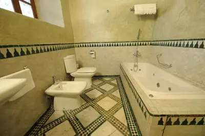 a bathroom with a toilet and a tub and a sink at Riad Au 20 Jasmins in Fès