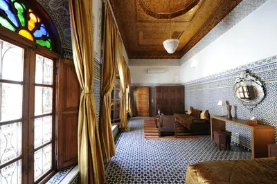 a living room with a couch and a stained glass window at Riad Au 20 Jasmins in Fès