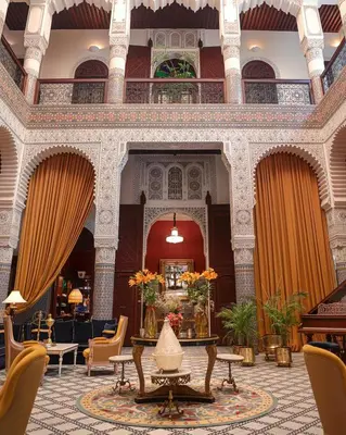 a lobby with chairs and a table in a building at Riad Fes - Relais & Châteaux in Fès