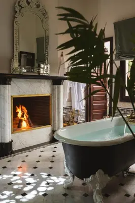 a bath tub in a room with a fireplace at Riad Fes - Relais & Châteaux in Fès
