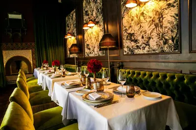 a row of tables in a restaurant with white table settings at Riad Fes - Relais & Châteaux in Fès
