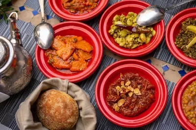 a table with red bowls filled with different types of food at Riad Fes - Relais & Châteaux in Fès