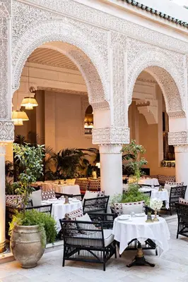 a restaurant with tables and chairs in a building at Riad Fes - Relais & Châteaux in Fès