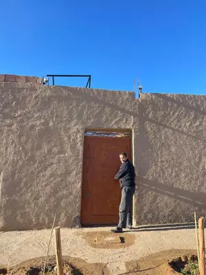 a man standing in front of a door at Guest House familly takojt in Merzouga