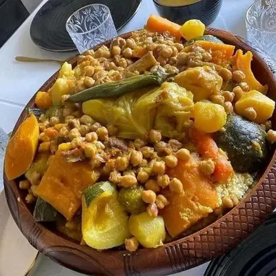 a plate of food with beans and vegetables on a table at Guest House familly takojt in Merzouga