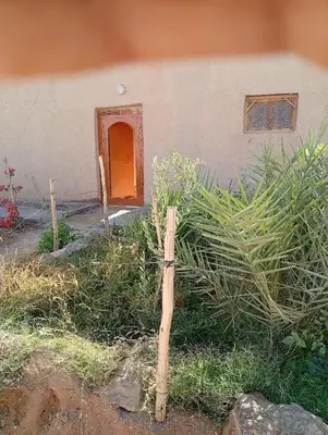 a wooden fence in front of a house at Guest House familly takojt in Merzouga