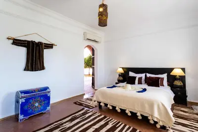 a bedroom with a bed and a cross on the wall at Kasbah Caracalla in Aghmat
