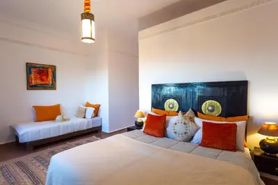 a bedroom with a large bed and a couch at Kasbah Caracalla in Aghmat