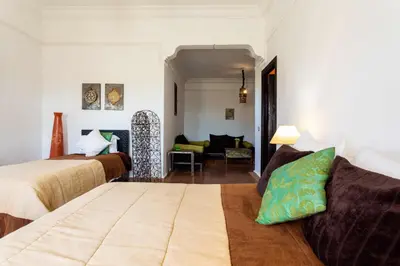 a bedroom with two beds and a living room at Kasbah Caracalla in Aghmat