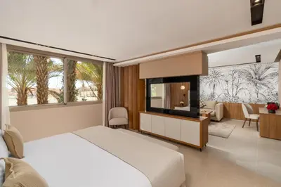 a bedroom with a white bed and a large window at Kenzi Rissani in Er Rachidia