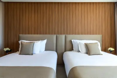 two beds sitting next to each other in a room at Kenzi Rissani in Er Rachidia