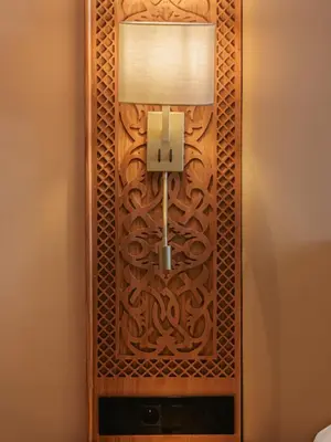 a wooden partition with a lamp on a wall at Kenzi Azghor in Ouarzazate