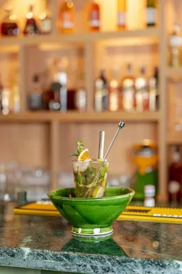 a green bowl on a counter with a drink in it at Kenzi Azghor in Ouarzazate