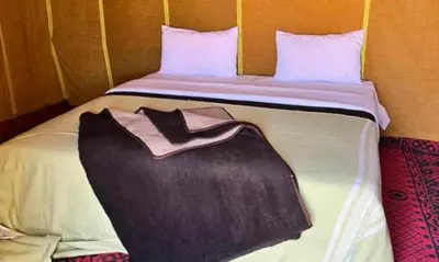 a bed in a room with a robe on it at Your journey starts here in Merzouga