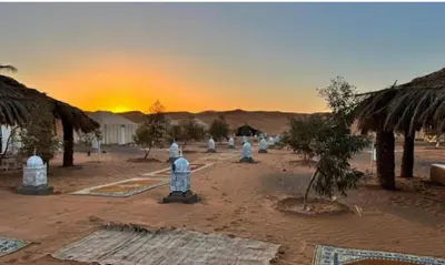 a group of statues in the desert with the sunset at Your journey starts here in Merzouga
