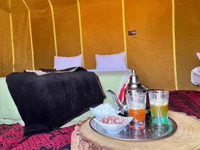 a table with a tray of food and drinks on a bed at Your journey starts here in Merzouga