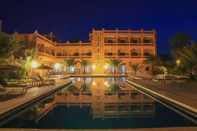 a hotel with a pool in front of a building at La Perle Du Drâa in Zagora