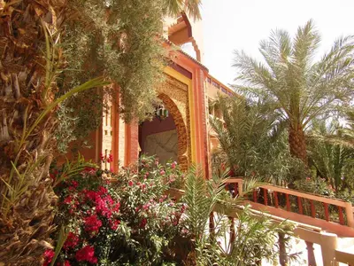 a building with a bunch of plants and flowers at La Perle Du Drâa in Zagora