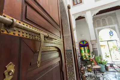 a wooden door with a handle in a room at Riad Norma in Fès