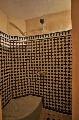 a bathroom with a shower with black and white tiles at Riad Dar Chrifa - Luxury Escape in Fès