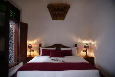 a bedroom with a large bed with red pillows at Riad Dar Chrifa - Luxury Escape in Fès