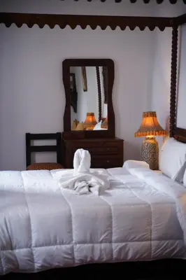 a bedroom with a white bed and a mirror at Riad Dar Chrifa - Luxury Escape in Fès