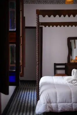 a bedroom with a canopy bed and a mirror at Riad Dar Chrifa - Luxury Escape in Fès