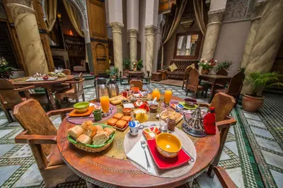 a table with food and orange juice on it at Dar victoria in Fès