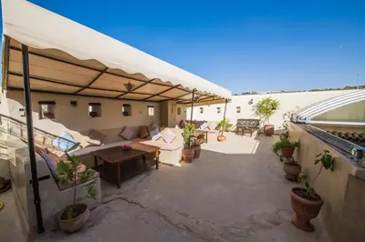 an outdoor patio with a couch and tables and plants at Dar victoria in Fès