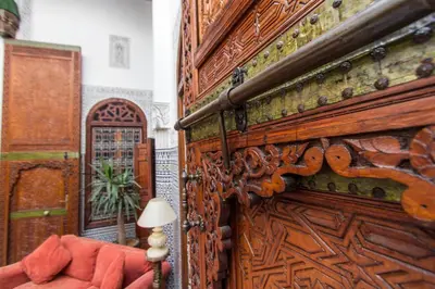 a room with a large wooden door and a couch at Riad - Dar Al Andalous in Fès
