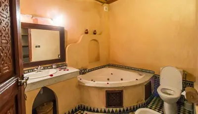 a bathroom with a tub and a toilet and a sink at Riad - Dar Al Andalous in Fès