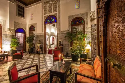 a living room with furniture and stained glass windows at Riad - Dar Al Andalous in Fès
