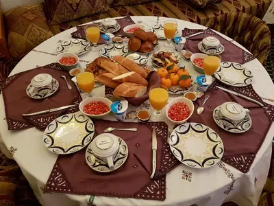 a table with a plate of breakfast foods and orange juice at Riad Souafine in Fès