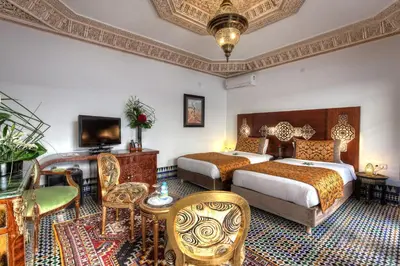 a hotel room with two beds and a television at Riad El Amine Fès - Historic Hotels Worldwide in Fès
