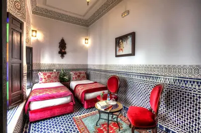 a room with a bed and a table and chairs at Riad El Amine Fès - Historic Hotels Worldwide in Fès