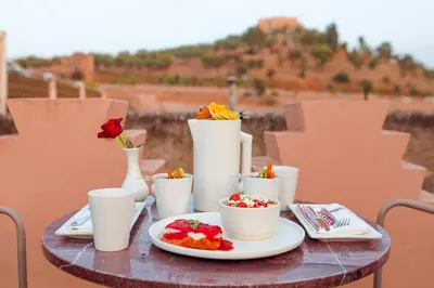 a table with plates of food and vases and flowers at Riad El Amine Fès - Historic Hotels Worldwide in Fès