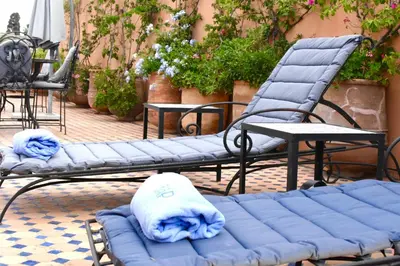 two chairs and a blue couch on a patio at Riad Yacout in Meknès