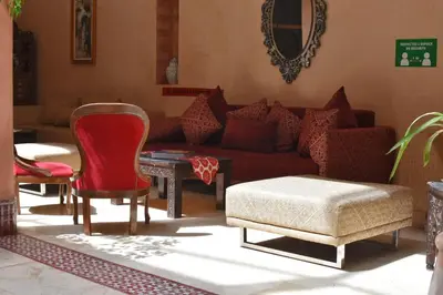 a living room with a red couch and chairs at Riad Yacout in Meknès