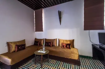 a room with a couch and a table and a tv at Riad Fez Yamanda in Fès