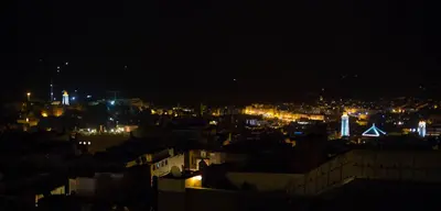 a view of a city at night with lights at Riad Fez Yamanda in Fès