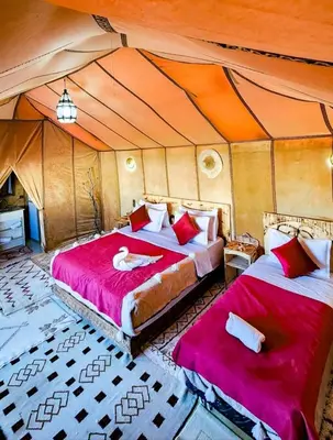 a bedroom with two beds in a tent at Original Luxury Camp in Merzouga